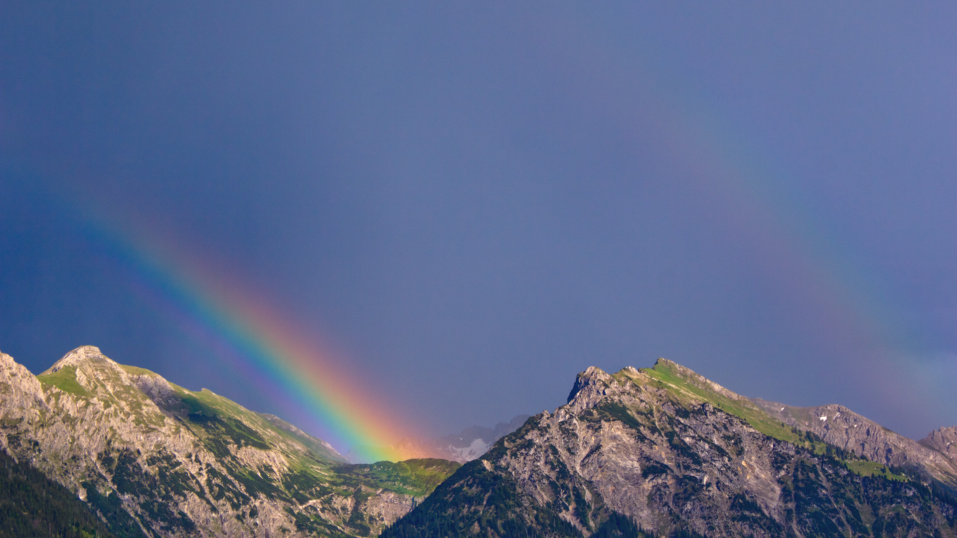 Arcane Spectacle: A Double Rainbow Over Majestic Mountains